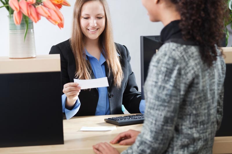 bank-teller-looking-at-deposit-slip-800.jpg